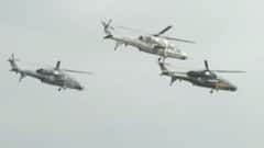 Attack helicopters roar in the sky during Aero India 2021