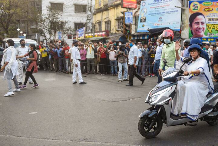 অনভ্যস্ত হাতে ধীর গতিতে ই-স্কুটার এগিয়ে নিয়ে যান মমতা বন্দ্যোপাধ্যায়। চালানোর অভ্যেস নেই। তবে মমতা বন্দ্যোপাধ্যায় দমার পাত্র নন। অপটু হাতে একবার একটু হেলে পড়ে স্কুটার। রাস্তার ধারে দাঁড়িয়ে থাকা পথচারীদের উদ্দেশে তাঁকে হাত নাড়তেও দেখা যায়।