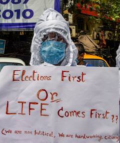 WB Election 2021: নির্বাচন আগে ? নাকি জীবন?... ভোট বন্ধের দাবিতে কমিশনের অফিসের সামনেই PPE পরে রাস্তায় শুয়ে প্রতিবাদ