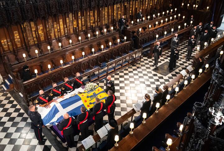 Queen Elizabeth watches as pallbearers carry the coffin of the Duke of Edinburgh during his funeral, at St Georges Chapel in Windsor Castle, Windsor, England. Prince Philip died April 9 at the age of 99 after 73 years of marriage to Britains Queen Elizabeth II. (Image: PTI)