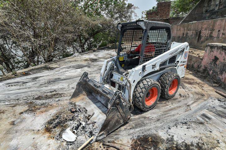 An earthmover is used to remove ashes of Covid victims in Bhairav Ghat Hindu Crematory In Kanpur. Amid the spike in fatalities, several heart-breaking visuals have emerged from Kanpur city showing bodies piling up at crematoriums. (Image: PTI)