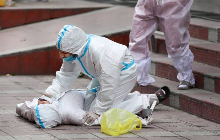Family members rush to attend a woman who fainted during the cremation of a Covid victim in Jammu. With the Covid-19 graph witnessing an upward trend in the Union Territory, the J&K administration said that the situation is 'challenging' because the growth rate of positive cases is 8.12 per cent, which is higher than it was last year. (Image: PTI)
