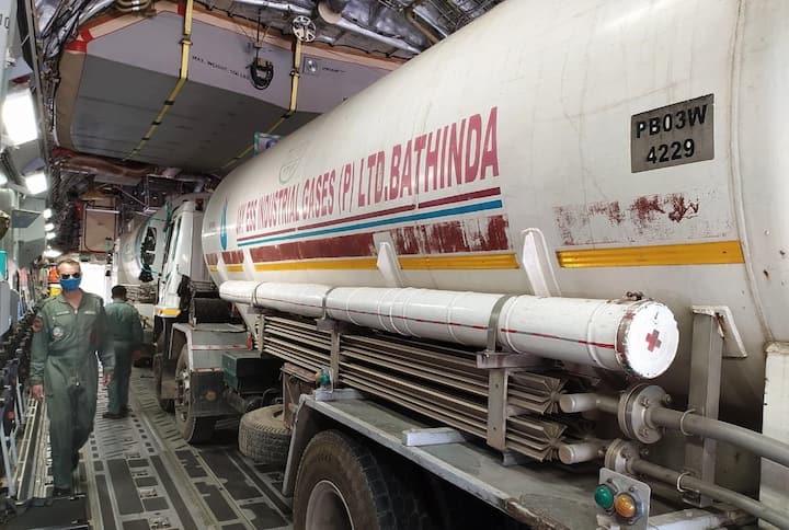 द्रवरूप वैद्यकीय ऑक्सीजनची वाहतूक करणारे रिक्त कंटेनर ट्रक्स वेळेची बचत करण्यासाठी विमानातून नेत आहेत .