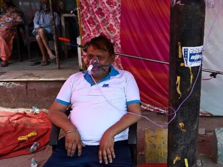 ஆக்சிஜன் உதவியுடன் அமர்ந்திருக்கும் கொரோனா நோயாளி. இந்த வசதி அவருக்கு உதவுகிறது