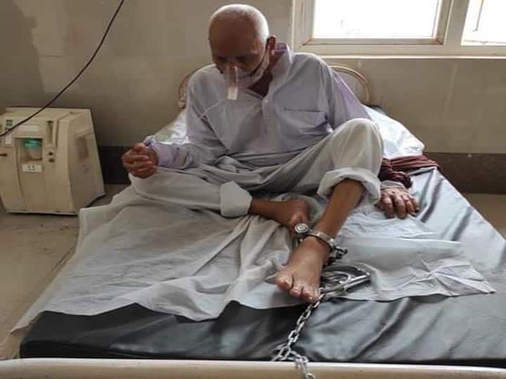 Old Prisoner tied with bed in Etah district hospital ann यूपी से सामने आई झकझोर देने वाली तस्वीर, बुजुर्ग कैदी का बिस्तर से बांधकर किया जा रहा है इलाज