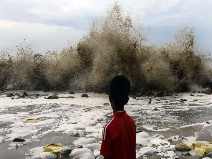 தாக்டே புயல் எதிரொலியால் கொந்தளிக்கும் கடலும் வேடிக்கை பார்க்கும் சிறுவனும்