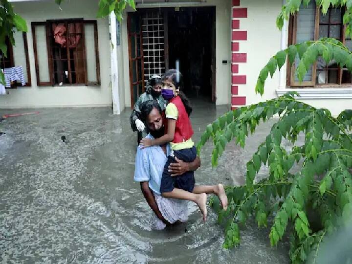 மழையால் வீட்டினுள் தண்ணீர் புகுந்த நிலையில் பாதுகாப்பான இடம் தேடி செல்லும் குடும்பத்தினர்