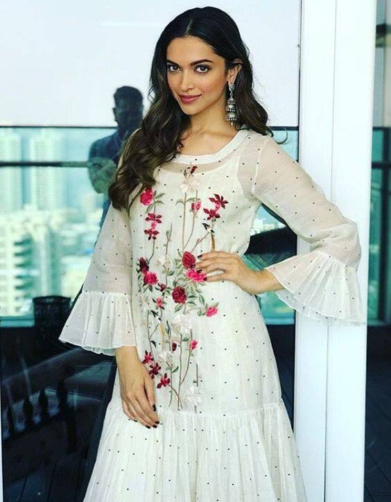 Deepika Padukone- अपनी सफेद मैक्सी सफेद ड्रेस को अलग लुक देने के लिए दीपिका ने फ्रिंज  स्लीव्स और फ्रिंज हेमलाइन के साथ एक्सपेरिमेंट किया है. उसके आउटफिट में सामने की तरफ कढ़ाईदार  फ्लोरल वर्क था जो दीपिका की ड्रेस को एक एथनिक ट्विस्ट दे रहा है. सिल्वर इयररिंग्स और  आरामदायक जूतियों के साथ एक्ट्रेस ने इस लुक को पूरा किया.