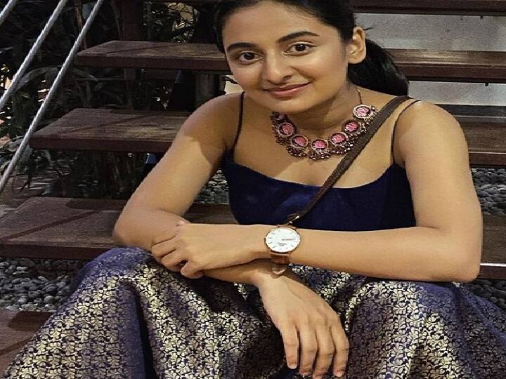 படிக்கட்டில் அமர்ந்தபடி மெல்லிய புன்சிரிப்புடன் ஒரு போஸ்