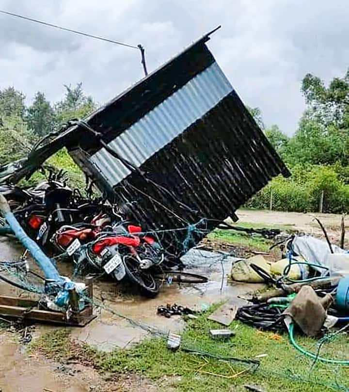 গ্রামের অধিকাংশ বাসিন্দাকেই সাইক্লোন রিলিফ সেন্টারে নিয়ে যাওয়া হলেও, কিছু মানুষ এই দুর্যোগের মধ্যেও ভিটেমাটি আকড়ে পড়ে রয়েছেন। (ছবি-কেন্দ্রাপাড়ার গ্রামে মোটরসাইকেলের ওপর উল্টে পড়েছে টিনের গুমটি)