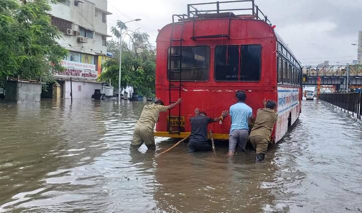 மழைநீரில் பழுதாகி நின்ற பேருந்தை தள்ளுகின்றனர்