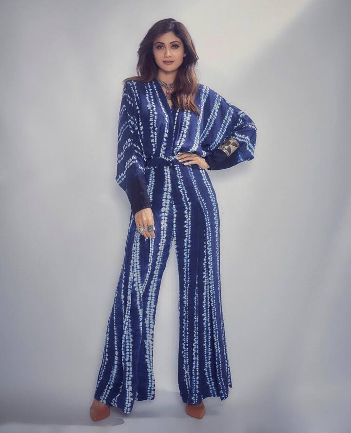Shilpa Shetty- शिल्पा शेट्टी कुंद्रा अपने जंपसूट में देसी मोड़ जोड़ने में कामयाब रही. जंपसूट डार्क ब्लू शिबोरी प्रिंट धारियों के साथ इस जंपसूट में डोमेन स्लीव्स थी. शिल्पा ने ट्रडिशनल सिल्वर ज्वैलरी के साथ लुक को एक्सेसराइज़ किया.