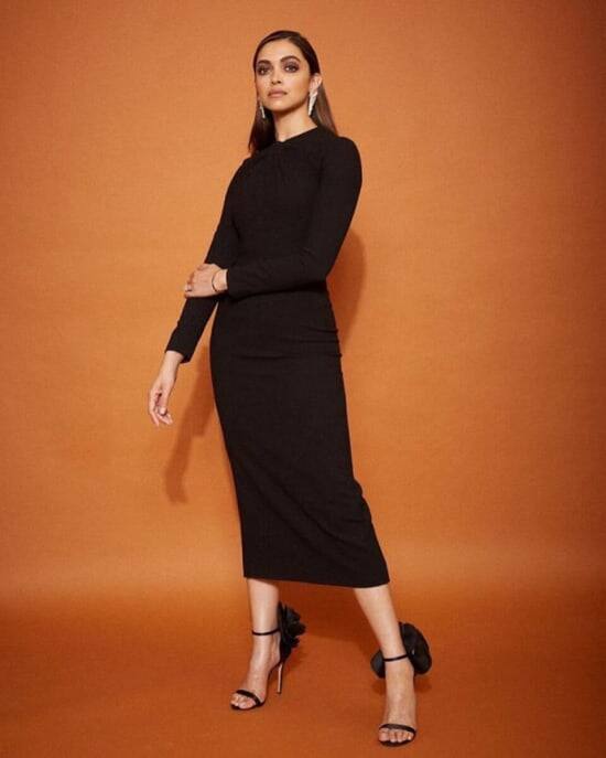 दीपिका पादुकोण ने एक पूरी बाजू वाली ब्लैक मिडी ड्रेस का चुनाव किया. नॉटेड नेकलाइन इस ड्रेस को और स्टाइलिश बना रही थी. स्पार्कलिंग इयररिंग्स, ब्लैक स्ट्रैपी हील्स और रेड लिप्ट के साथ एक्ट्रेस ने इस लुक को पूरा किया.