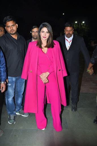 प्रियंका ने एक फ्यूशिया पिंक जंपसूट पहना था, जिसे उन्होंने मैंचिंग ओवरकोट के साथ पेयर किया. जंपसूट में पैंट के किनारों पर फ्लेयर्ड बॉटम, बैलून स्लीव्स और बटन डिटेल्स थे.  पिंक लिप्स, हूप इयररिंग्स और स्लीक साइड-पार्टेड हेयरडू के साथ एक्ट्रेस ने बॉस  लेडी लुक को कम्पलीट किया.