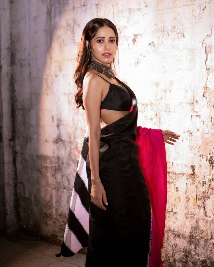 नुसरत ने एक स्टाइलिश ट्रिपल टोन साड़ी को चुना जिसमें मोनोक्रोम ब्लैक एंड व्हाइट के अलावा ब्राइट पिंक कलर था. एक स्टेटमेंट ऑक्सीडाइज्ड नेकलेस और पोकर-स्ट्रेट बालों ने एक्ट्रेस के लुक को पूरा किया.