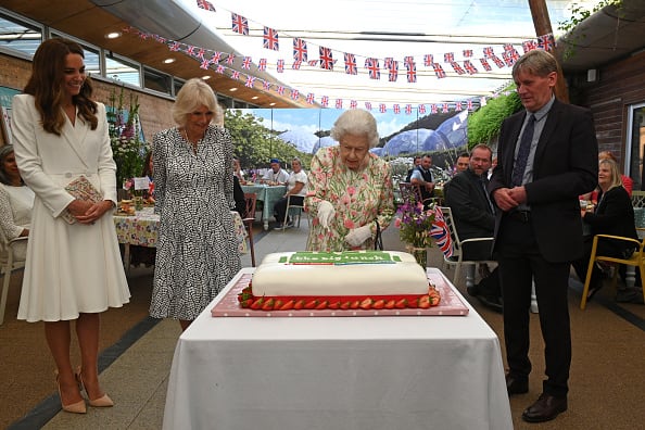 Queen Elizabeth made everyone giggle at Eden Project's Big Lunch event on Friday by using the ceremonial sword to cut the cake. [pic credit: Gettyimages]
