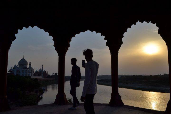 People take photographs of the historic Taj Mahal at sunset ahead of its reopening in Agra. The Taj Mahal and other centrally protected monuments, which were closed two months ago in the wake of the second Covid-19 wave, will reopen on June 16, the Archaeological Survey of India (ASI) said. Visitors will be able to book entry tickets online and no offline booking facility will be available, an ASI official said. (Image: PTI)