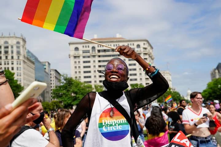 வாஷிங்க்டனில் நடந்த ப்ரைட் திருவிழாவில் கொடி அசைத்துக் கொண்டாடும் நபர்