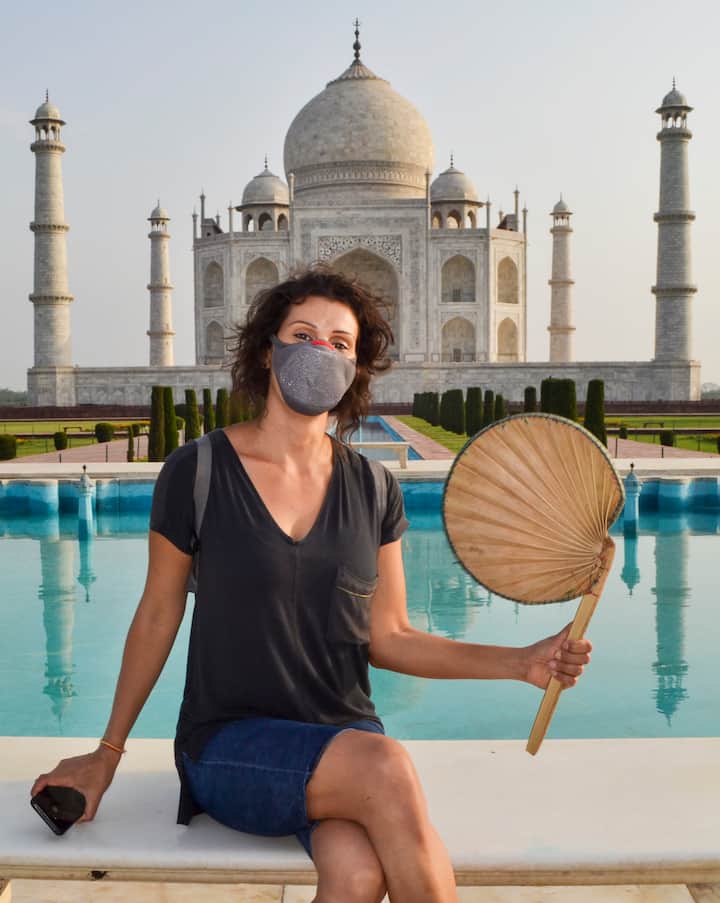 Agra: A foreign tourist poses for a photo in front of the Taj Mahal. As per the issued guidelines, no more than 650 people will be allowed inside Taj Mahal at a given time. Teams will be deputed to monitor the crowd. (Image: PTI)