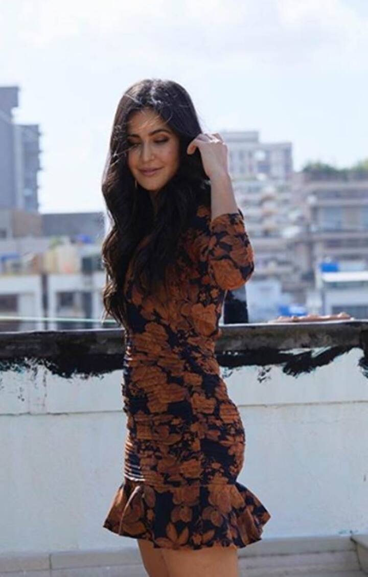 कैटरीना कैफ की मिनी ड्रेस हर किसी को पसंद आएगी. इस ड्रेस में फुल स्लीव्स, डीप वी नेक और हेम पर रफ़ल डिटेल्स थे. उसकी बॉडीकॉन ड्रेस में ब्राउन कलर का फ्लोरल डिज़ाइन था जो इसे समर परफेक्ट आउटफिट बना रहा था. कैटरीना ने अपने लुक को लाइट मेकअप के साथ पूरा किया.