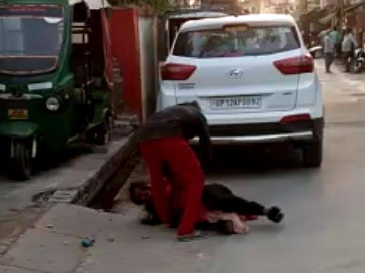 video surfaces of man beating his wife brutally on road in Pilibhit ANN पीलीभीत: गुस्साए पति ने बीच बाजार पत्नी पर बजाए लात-घूंसे, वीडियो बनाते रहे लोग