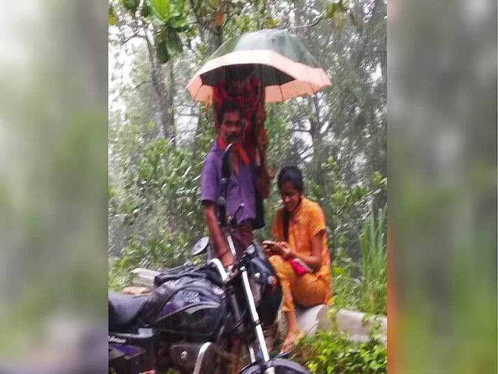 Man holds umbrella to protect daughter from rain as she attends online class by the road. ”மக ஆன்லைன் கிளாஸ் அட்டெண்ட் பண்ணனும்” - கொட்டும் மழையில் குடை பிடித்த தந்தை : வைரல் புகைப்படம்