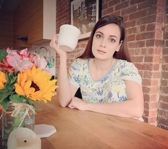 દિયાના કિચરમાં સફેદ ટાઇલ વાળી દિવાલો અને લાકડાની છાજલીઓ બનાવેલી છે.