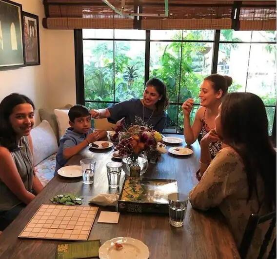 ડાયનિંગ એરિયામાં એક લાંબુ બ્રાઉન કલરનુ ટેબલ લગાવેલુ છે, જેમાં એકબાજુ સોફા છે, અને બીજી બાજુ ચેર છે, જે કિચનની બિલકુલ પાસે છે.