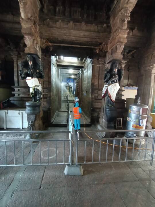 பக்தர்கள் செல்லும் பகுதியில் கிருமி நாசினி தெளிக்கும் பணி