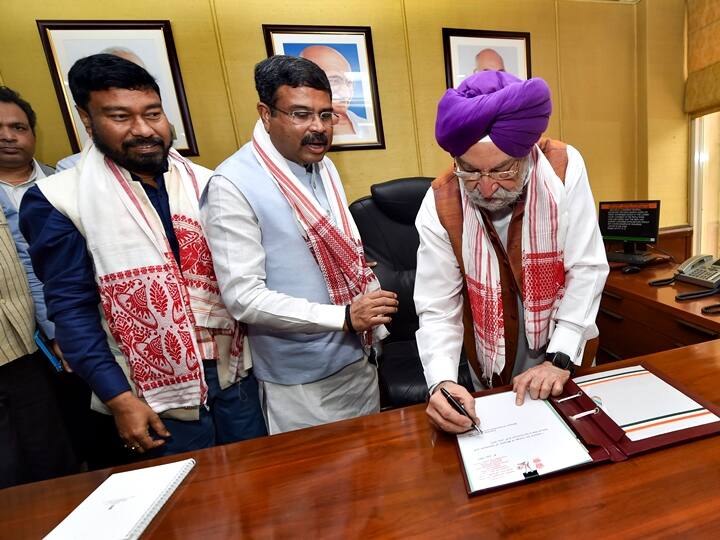 New Delhi: Union Petroleum Minister Hardeep Singh Puri singed the paper as Union Minister Dharmendra Pradhan (C) and MoS Rameswar Teli (R) looks on while taking charge at his office, in New Delhi, Thursday, July 8, 2021. (PTI Photo/Manvender Vashist)