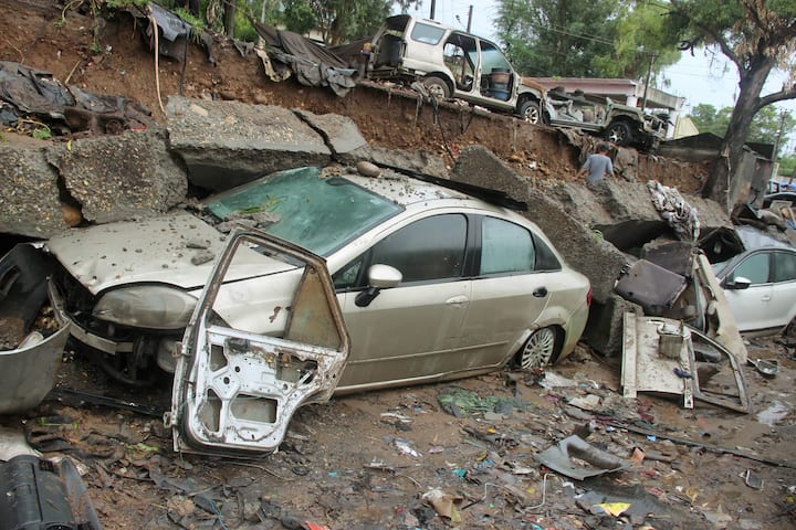 Jammu: A wall collapsed and damaged vehicles after heavy rainfall at Kalka colony in Jammu. (Image: PTI)