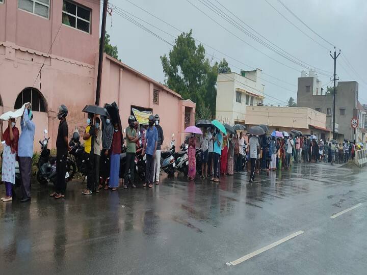 People waiting in the rain to be vaccinated கோவை : கொரோனா தடுப்பூசிக்காக கொட்டும் மழையில் குடை பிடித்து காத்திருந்த மக்கள்!