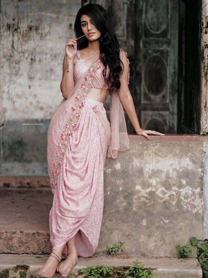 The 'Oru Adaar Love' actress is an absolute stunner in a pink dhoti style saree.