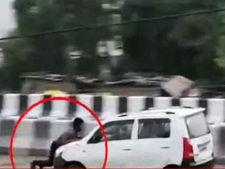 Kanpur Viral Video: Young Man Hanging On Front Car Bonnet Driver Not Stop Car कार के आगे बोनट पकड़े लटका रहा युवक, चालक ने नहीं रोकी गाड़ी, फिल्मी अंदाज में किया स्टंट