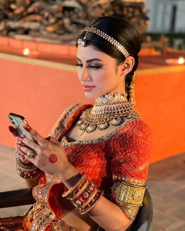 इसके साथ ही उन्होंने हाथों में राजस्थानी चूड़ा और माथे पर एक बहुत ही प्यारा सा बोरला भी लगाया हुआ है. जो उनकी खूबसूरती में चार चांद लगा रहा है. तस्वीरों में मौनी चेयर पर बैठी हुई फोन में कुछ करती नजर आ रही हैं.