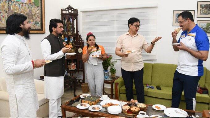 మీరాబాయి చాను కోచ్తో మాట్లాడుతున్న కేంద్ర మంత్రి కిరణ్ రిజుజు.