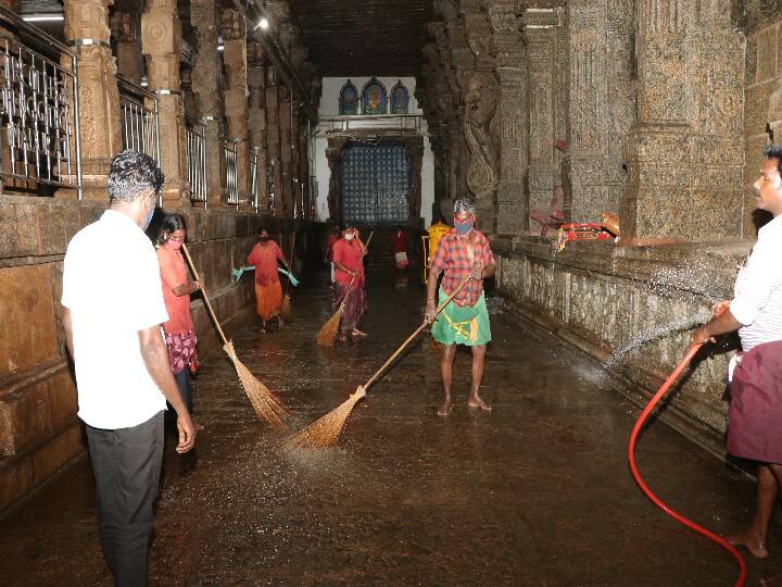 அழகர்கோவில் மண்டபத்தில் கிருமி நாசினி தெளிக்கும் காட்சி