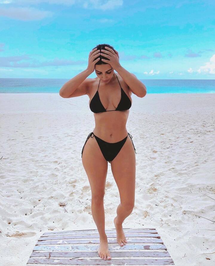 In a second pic, she faced the camera straight-on placing her hands on her head and looking down towards her feet. She captioned the sultry photos,