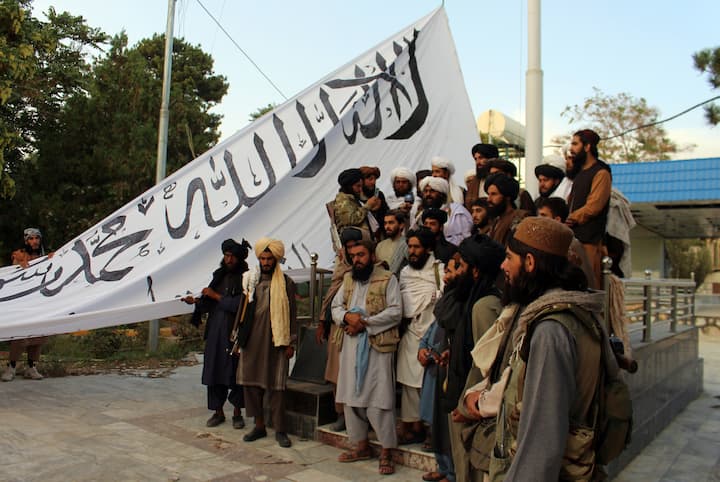 Taliban fighters raise their flag at the Ghazni provincial governor's house, in Ghazni, southeastern, Afghanistan, Sunday, Aug. 15, 2021. (Image Source: AP/Gulabuddin Amiri)