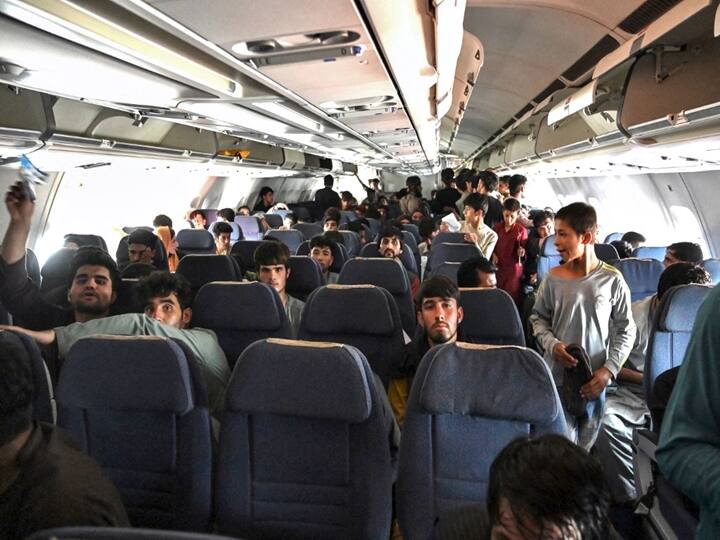 Afghan passengers sit inside a plane as they wait to leave the Kabul airport in Kabul. (Wakil Kohsar / AFP)