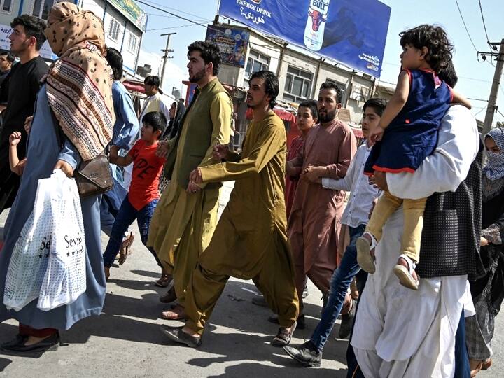 Afghan people run towards the Kabul airport to leave Kabul on August 16, 2021. (Wakil Kohsar / AFP)