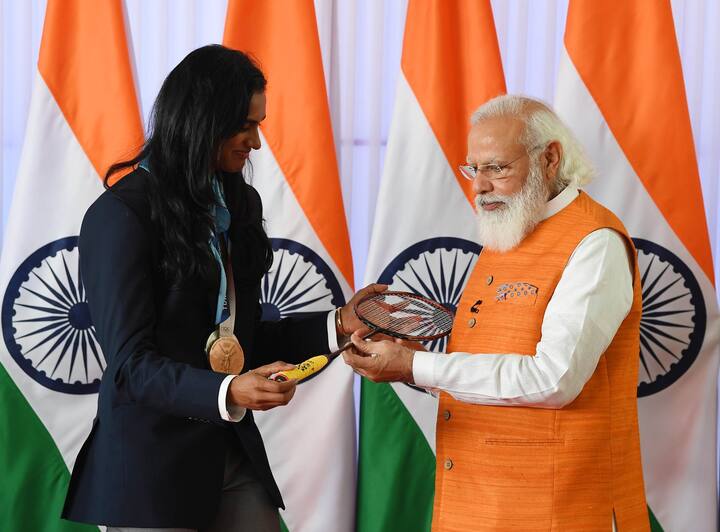 తాను సంతకం చేసిన రాకెట్ను మోదీకి కానుకగా ఇస్తున్న సింధు.