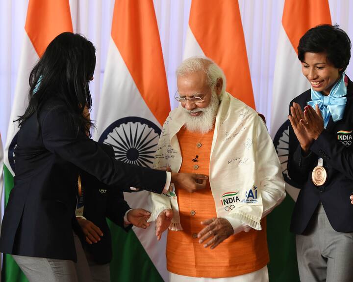 పతకాలు గెలిచిన ఆటగాళ్లు సంతకం చేసిన శాలువాతో మోదీని సత్కరిస్తోన్న టోక్యో ఒలింపిక్స్ పతక విజేతలు.