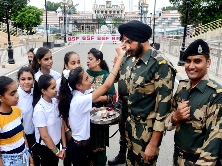 Girls tie rakhi to Border Security Force (BSF) jawans on the occasion of Raksha Bandhan festival at Attari-Wagha border near, Amritsar, Sunday, Aug. 22, 2021. (PTI Photo)