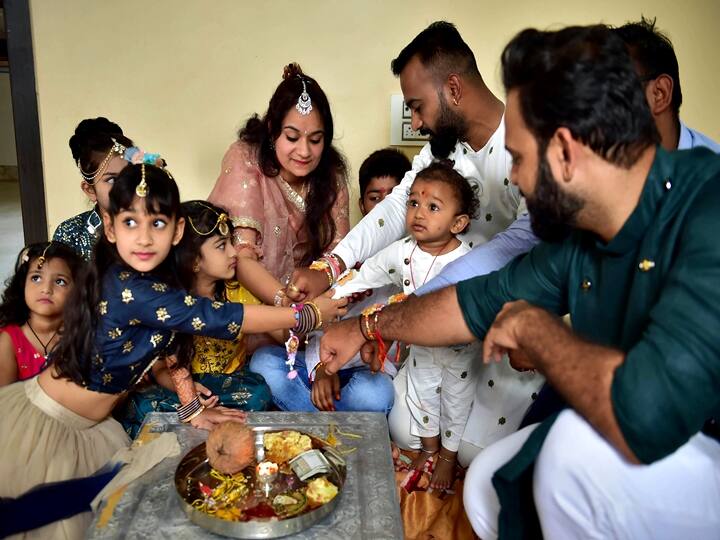 Bengaluru: A sister ties Rakhi to her brothers on the occasion of Raksha Bandhan festival, in Bengaluru, Sunday, Aug. 22, 2021. (PTI Photo/Shailendra Bhojak)