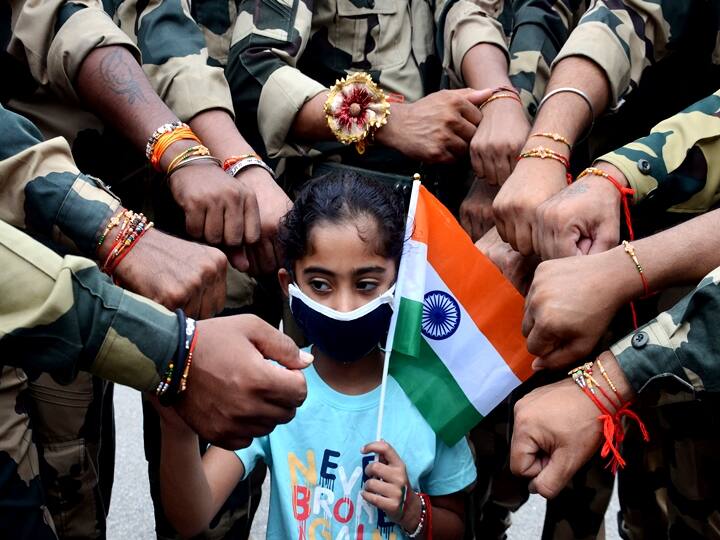 A girl ties rakhi on the wrists of Border Security Force (BSF) jawans on the occasion of Raksha Bandhan festival at Attari-Wagha border near, Amritsar, Sunday, Aug. 22, 2021. (PTI Photo)