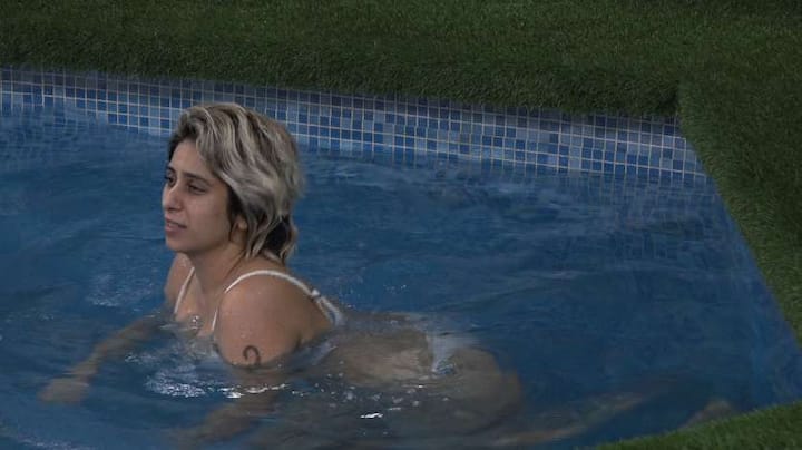 Neha Bhasin set the temperatures soaring in the Bigg Boss house as she stepped into the pool while posing in a stunning white bikini. [pic credit: Voot]
