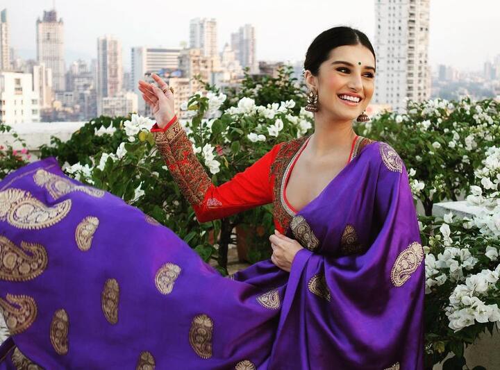 इस पर्पल और रेड कॉम्बिनेशन में तारा सुतारिया ने परफेक्ट ट्रडिशनल पोज दिया. बंधे बाल, कानों में झुमके की जोड़ी और माथे पर बिंदी के साथ एक्ट्रेस ने हर किसी का दिल जीता.
