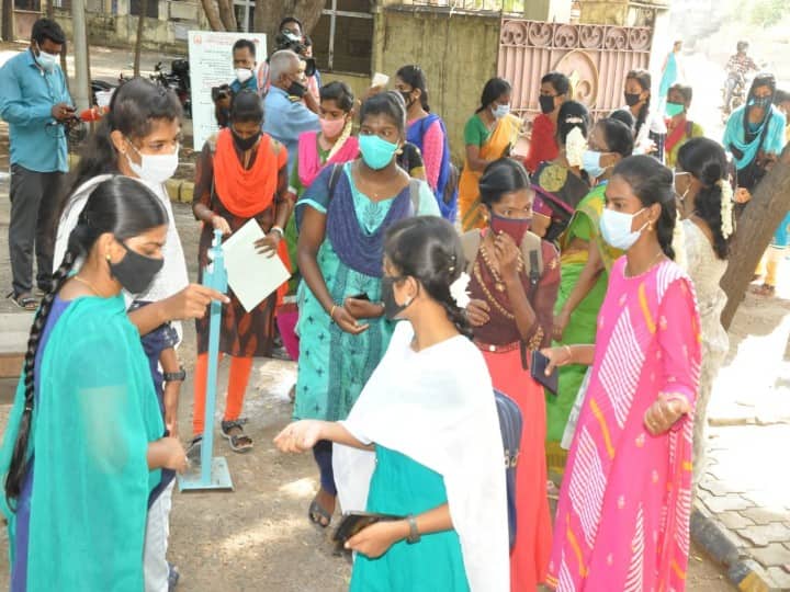 கல்லூரி மாணவிகள் கையில் கிருமிநாசினி தெளித்துக்கொள்ளும் காட்சி.