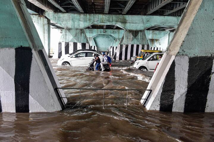 Vehicles ply on the waterlogged Bahadur Shah Zafar Marg after heavy rain at ITO in New Delhi. (Image Source: PTI)